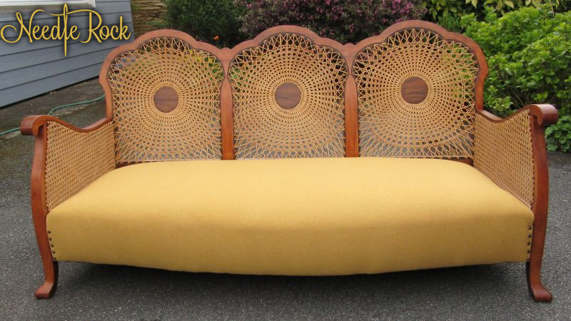 Gorgeous Bergère Sofa with refurbished circular caning, traditional upholstery, and vibrant mustard woolen fabric.