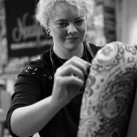 About Us: Jason, Needle Rock's skilled apprentice and classic car upholstery specialist, working on a patterned chair in the workshop.